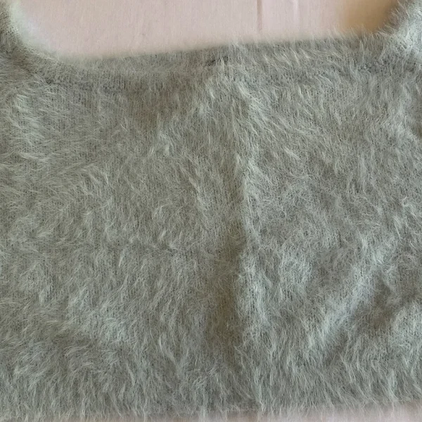 a grey furry object on a white surface