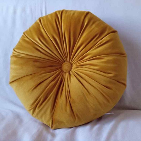 a yellow pillow on a white surface