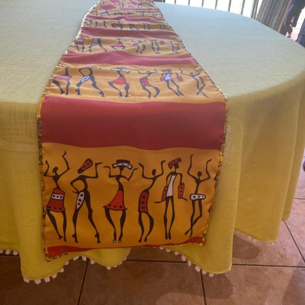 a table with a yellow tablecloth with a yellow table runner on it
